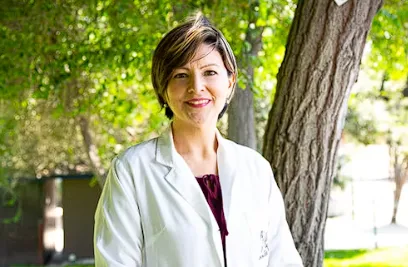 Female physician in white coat outdoors